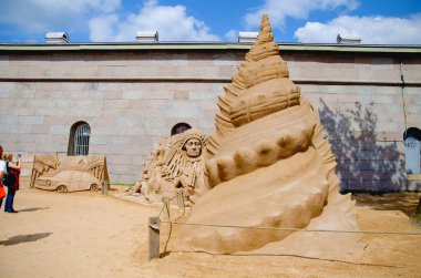 Kum figürleri festivali. Koni şeklinde bir deniz kabuğu heykeli. Grubun bakış açısına göre Meksika teması ve retro araba..