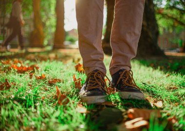 Adam çimlerin üzerinde duruyor.