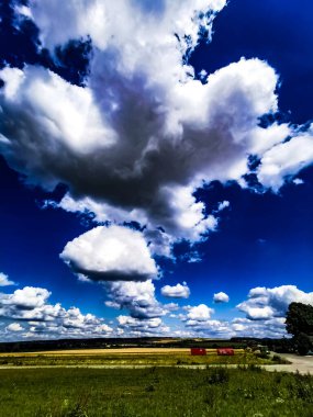 Yazın bulutlu mavi gökyüzü ve yeşil alan arkaplanı