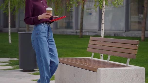ビジネスマンの女性は仕事から休憩し コーヒーを飲みながらオフィスの外のベンチに座っています カジュアルなスタイルを着て 晴れた日 肖像画はかなり成功した白人女性 スローモーションビデオ — ストック動画