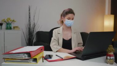 Hasta iş kadını maskeyle çalışırken hapşırıyor. Pandemik dönem. Karantina çalışma havası. Hasta Kafkasyalı kadın evden çalışıyor olmalı. Acil projeler.