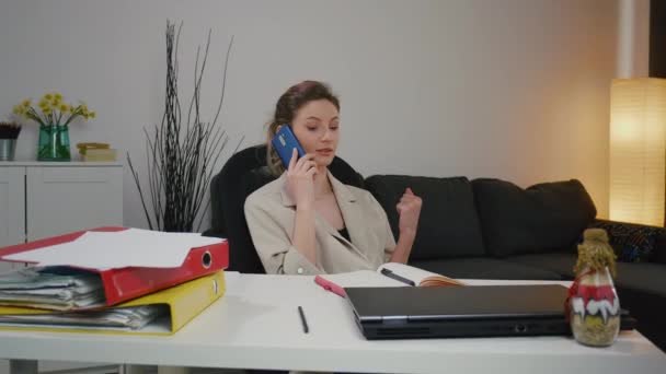 若い白人起業家マネージャーはオフィスで電話で話します ビジネス上の問題を解決する 顔のジェスチャーを表現して説明します 顧客との電話での会話 女性は電話をかける — ストック動画