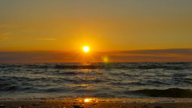 Renkli plaj gündoğumu ve güneş ışınları, sakinlik, dinlendirici güneş ışığı yaz havası. Yakın deniz kumsalı..