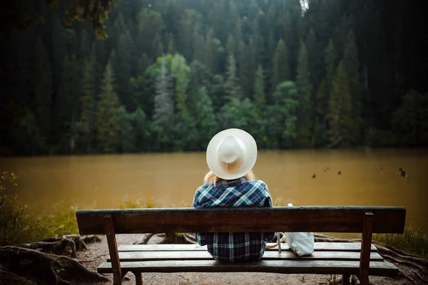 Bakifrån Ung Kvinna Jeansskjorta Och Hatt Sitter Bänk Bredvid Ett — Stockfoto