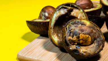 Çürük Avokado 'yu kapatın. Çirkin Tropik meyveler. Kirlenmiş Avokado yarıları. Nekomestibile meyveleri. Detaylar Olgunlaşmış Avokado. Yardımcı olmayan yiyecekler..
