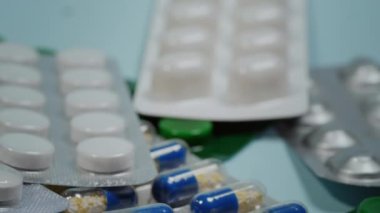 Mavi arka planda çeşitli şekil ve renklerde kabarcık, hap, tablet ve kapsüller