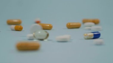 Bir insan tıbbı başkasına verir. Haplar mavi arka planda..