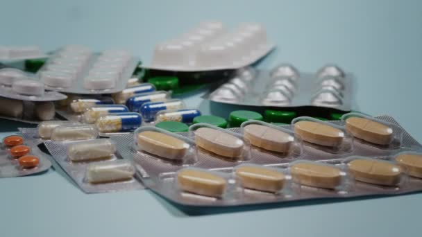 Pillen, Tabletten und Kapseln in verschiedenen Formen und Farben auf blauem Hintergrund.