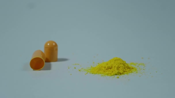 Offene Medizinische Kapsel Mit Gelbem Pulver Auf Blauem Hintergrund — Stockvideo