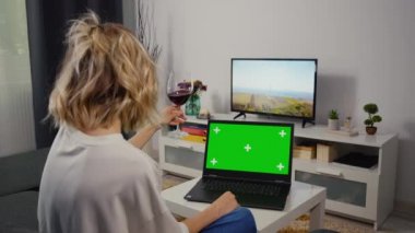 Gülümseyen kadın bir arkadaşıyla görüntülü sohbette bir hikaye anlatıyor. Boşluk Kroma Anahtarını Kopyalamak için Omuz üstünden Laptop Yeşil Ekran.