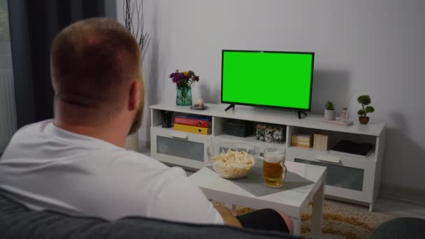 Muž Sledující Doma Televizi Zelenou Obrazovkou Pivo Pojídající Popcorn Ramenem — Stock video