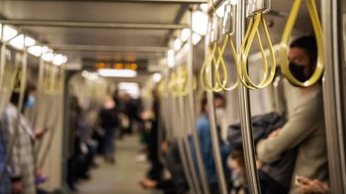 Metro 'da korkuluk asmak. Toplu taşıma yolcularının kayışlarında plastik sarılar var. Metro rayları, metrodaki insanlar..