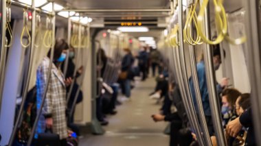 Metro 'da korkuluk asmak. Toplu taşıma yolcularının kayışlarında plastik sarılar var. Metro korkulukları. Metrodaki kadın telefona bakıyor..