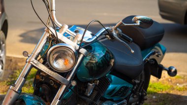 Yeşil çimlerin üzerine park edilmiş metalik mavi motosiklet