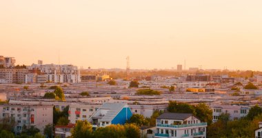 Aerial view of downtown cityscape in distance at sunset. Large view of housing viewed from balcony.