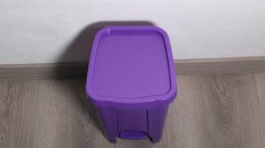 Adamın biri eski bir cerrahi maskeyi çöp kutusuna atıyor.