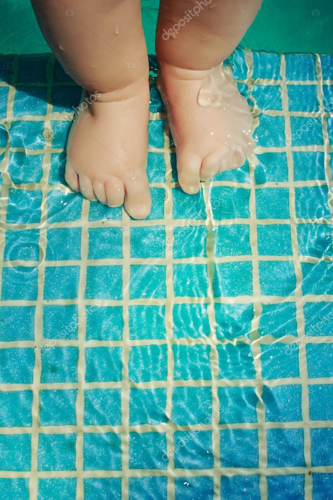Baby's feet in swimming pool — Stock Photo © AleksaMax 76646777