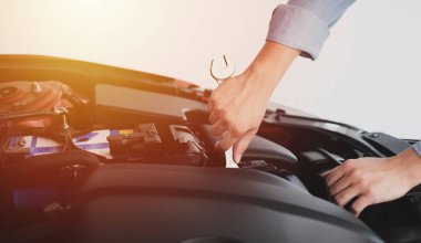 Arabanın motorunu fotokopi alanı ile tamir eden bir adam