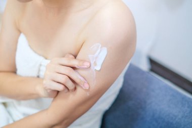Doğal krem süren bir kadın, kozmetik kremi, spa ve manikür konseptiyle kolunu nemlendiren bir kadın..
