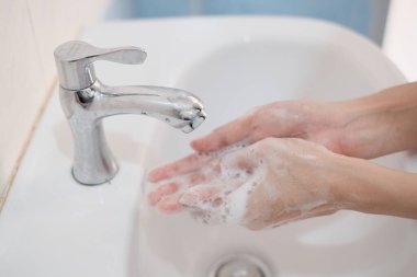 Kadın ellerini yıkıyor, Corona virüsü önlüyor, ellerini sabun ve sıcak suyla yıkıyor. Coronavirüs salgını için el hijyeni. El yıkama ile korunma sıklıkla kabul edilir.