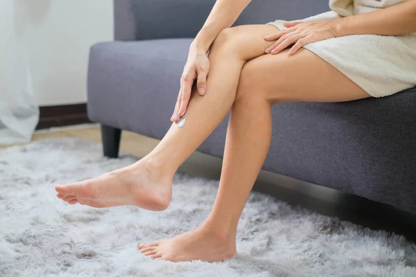 Woman applying natural cream, Woman moisturizing her leg with cosmetic cream with copy space.