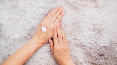 Kadın doğal krem sürüyor, kadın elini kozmetik krem, spa ve manikür konseptiyle nemlendiriyor..