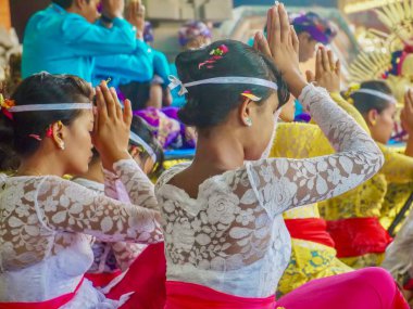 Ubud, Bali - 12 Ekim 2012. Geleneksel Bali tören kıyafetleri giyen Hindu bir kalabalık açık havada bir tapınakta dua ediyor..