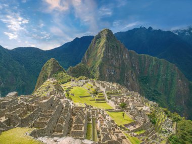 Machu Picchu 'nun ikonik taş kalıntıları ve güneşli bir günde dramatik Huayna Picchu dağı..