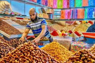 Marakeş, Fas - 22 Ekim 2015. Faslı bir adam halka açık bir markette çalışıyor. Tarih, fındık, baharat, şeker ve hediye kutusu satıyor..