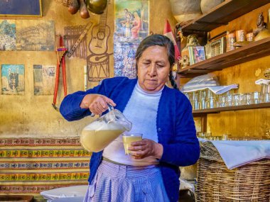 Urubamba, Peru - 25 Eylül 2011. Chicha 'yı gösteriyor, darıdan yapılan geleneksel sarı mayalanmış And içeceği, Perulu bir kadın tarafından Chicha tavernasında 