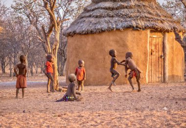 Kırsal Namibya - 21 Ağustos 2016. Bir grup mutlu çocuk Namibya 'daki Afrika Himba kabile köyünde çamurlu bir evde birlikte oynuyorlar..