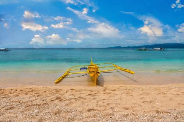 Filipinler 'in Puerto Galerisi' ndeki sığ turkuaz sularda yerel olarak Banca olarak adlandırılan geleneksel Filipin ahşap teknesiyle güzel bir tropikal ada sahnesi..