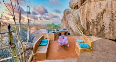 Kırsal Namibya - 21 Ağustos 2016. İllüstrasyon Editörü. Doğayla harmanlanmanın bir örneği, bu eşsiz açık hava yemek ve oturma alanı çöl manzarasında büyük antik kayalar arasında bir terasa inşa edilmiştir..