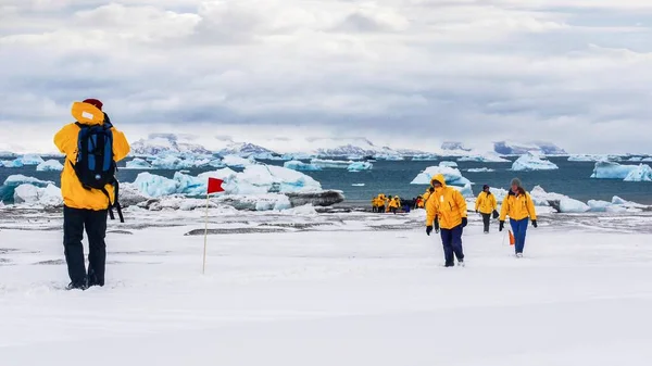 雪山岛 南极洲 2010年12月5日 旅游在南极洲 作为游客穿着配搭的帕卡走过雪地 背景是大海和冰山 — 图库照片