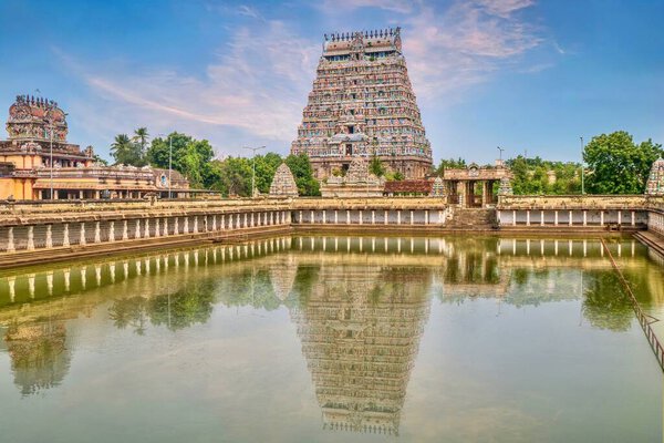 A large water pool reflecting the majestic tower of Nataraja Temple in Chidambaram, Tamil Nadu, South India.