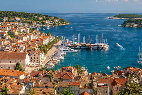 Высокоугольный вид на старый город и яхтенную гавань красивого и популярного курортного острова Хвар, далматинского острова в Адриатическом море в Хорватии. 