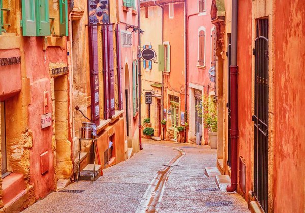 A narrow street in the beautiful French village of Roussillon, where the buildings are made of locally mined ochre and it is said that there are 17 different shades of color.