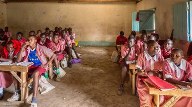 Maasai Mara, Kenya - 27 Eylül 2013. Afrika 'nın kırsal kesimindeki bir devlet okulunda, üniforma giyen öğrenciler, çıplak beton zemin ve duvarlar, ev yapımı ahşap masalar ve elektrik lambaları yok..