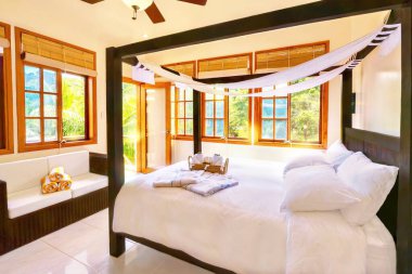 Filipinler 'deki tropikal bir adada, butik bir otelde, dört direkli ahşap bir yatağı ve rattan kanepesi olan, oldukça kaymak gibi beyaz bir tatil yeri..