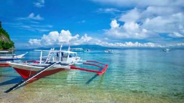 Filipinler 'in Mindoro Adası' ndaki bir tatil köyü olan Puerto Galera 'nın sığ turkuaz sularında yerel olarak Banca olarak bilinen geleneksel Filipinli ahşap iskele tekneleri..