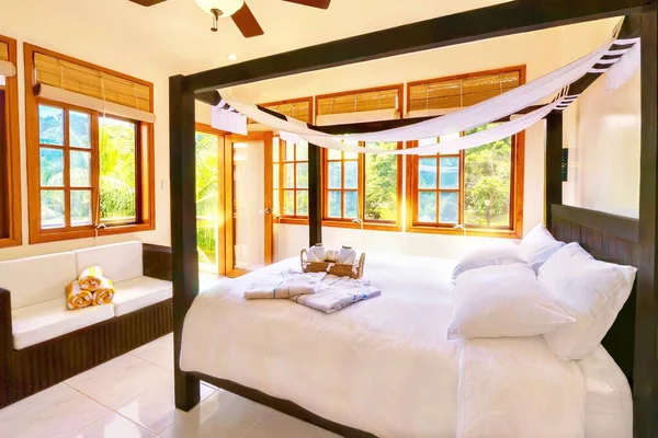 Filipinler 'deki tropikal bir adada, butik bir otelde, dört direkli ahşap bir yatağı ve rattan kanepesi olan, oldukça kaymak gibi beyaz bir tatil yeri..