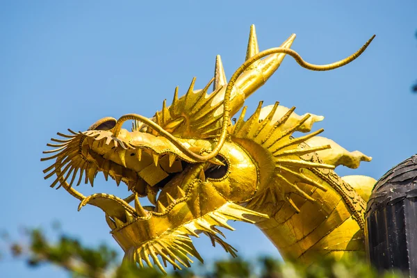 Dragon goud is gemaakt van schroot staal op blauwe hemelachtergrond. — Stockfoto