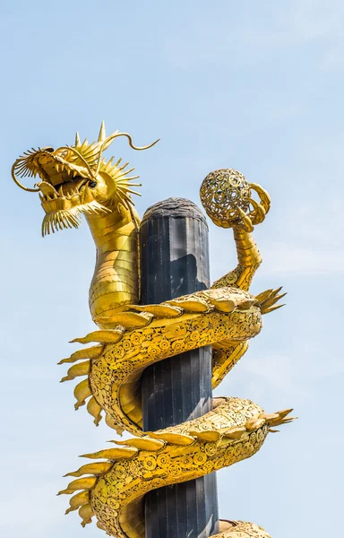 Dragon goud is gemaakt van schroot staal op blauwe hemelachtergrond. — Stockfoto