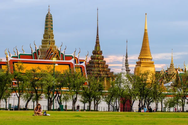 İnsanlar Sanam Luang Wat Phra Kaew ve Grand Palace önünde oturuyor