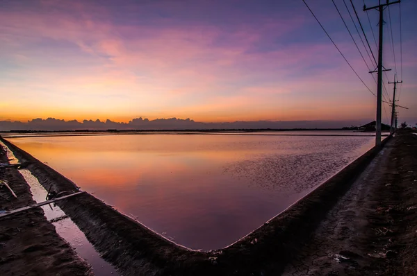 Світлий захід сонця на морській соляній фермі красиво — стокове фото