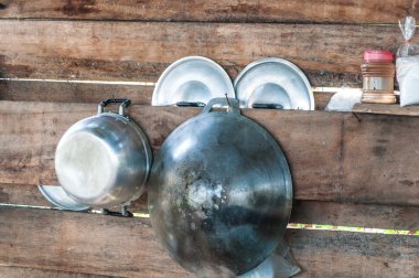 Ahşap bir duvarda asılı mutfak eşyaları