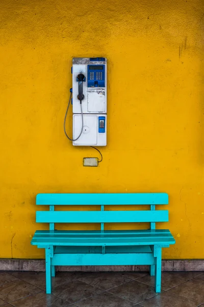 Sedia in legno antico blu con parete cellulare con sfondo giallo . — Foto Stock