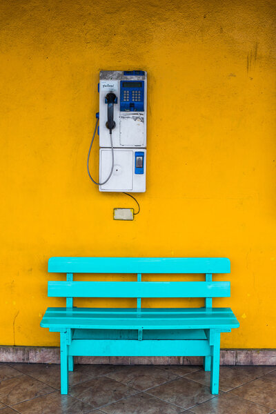 Antique wooden chair blue with cell wall with a yellow background.