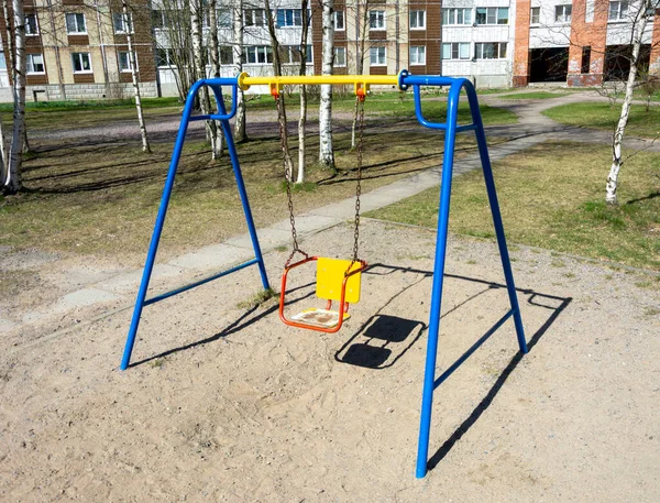 Çok katlı binaların bahçesindeki çocuk parkında renkli salıncaklar