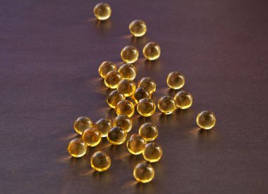 Kahverengi arka planda balık yağı vitaminleri